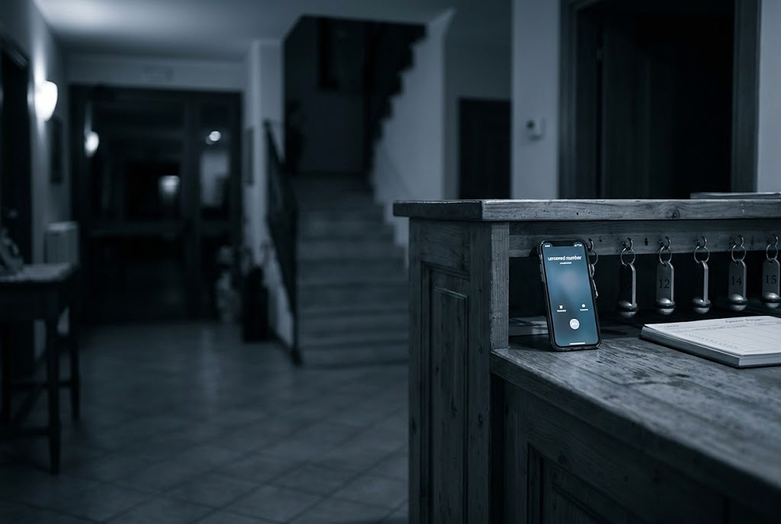 Reception di un piccolo hotel di notte con il telefono che squilla