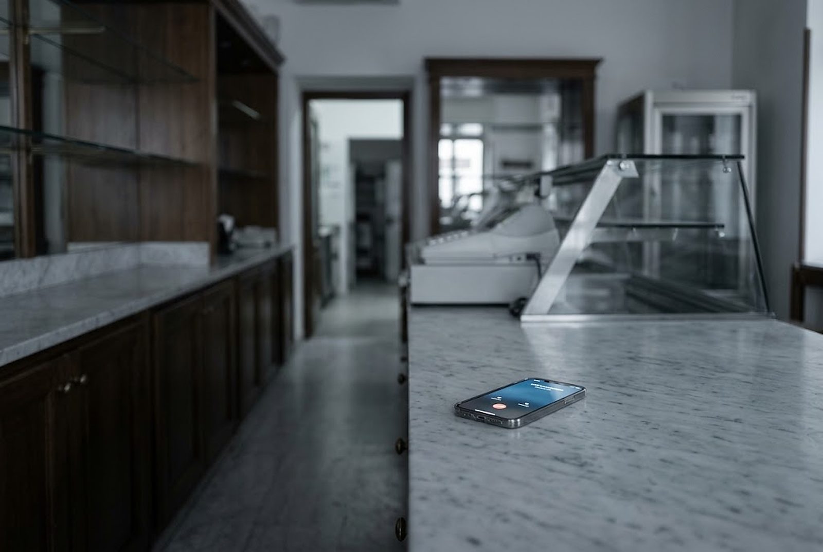 Bancone di una pasticceria con il telefono che squilla accanto alla cassa
